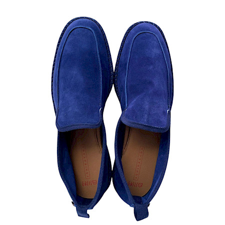 Dunkelblauer Slipper aus weichem Leder mit schlichter, eleganter Form und sichtbaren Ziernähten entlang der Seiten. Dunkelblauer Slipper aus weichem Leder mit schlichter, eleganter Form und sichtbaren Ziernähten entlang der Seiten.