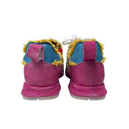 Bunter Sneaker mit auffälligem Patchwork-Design in Blau, Pink und Gelb, kombiniert mit Fransen-Details und weißen Schnürsenkeln. Bunter Sneaker mit auffälligem Patchwork-Design in Blau, Pink und Gelb, kombiniert mit Fransen-Details und weißen Schnürsenkeln.