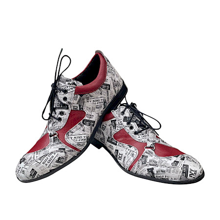 Auffälliger Schnürschuh mit schwarzer Sohle, rotem Leder und markantem Zeitungsmuster in Weiß-Schwarz, kombiniert zu einem modernen, eleganten Design. Auffälliger Schnürschuh mit schwarzer Sohle, rotem Leder und markantem Zeitungsmuster in Weiß-Schwarz, kombiniert zu einem modernen, eleganten Design.