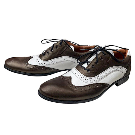 Eleganter Schnürschuh in braun-goldenem Farbton mit weißen Ledereinsätzen und klassischem Lochmuster, kombiniert mit schwarzer Sohle und feiner Schnürung. Eleganter Schnürschuh in braun-goldenem Farbton mit weißen Ledereinsätzen und klassischem Lochmuster, kombiniert mit schwarzer Sohle und feiner Schnürung.