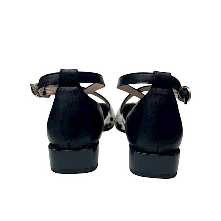 Eleganter Sling-Schuh mit spitzer Form, schwarzen Riemchen und auffälligem, bedrucktem Rindleder in Weiß mit natürlichen Flecken sowie kleinem Absatz. Eleganter Sling-Schuh mit spitzer Form, schwarzen Riemchen und auffälligem, bedrucktem Rindleder in Weiß mit natürlichen Flecken sowie kleinem Absatz.