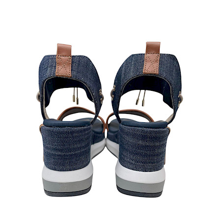 Plateau-Sandalette in Jeans-Blau mit cognacfarbenen Details, elastischen Riemen und heller, erhöhter Sohle in modernem Design. Plateau-Sandalette in Jeans-Blau mit cognacfarbenen Details, elastischen Riemen und heller, erhöhter Sohle in modernem Design.