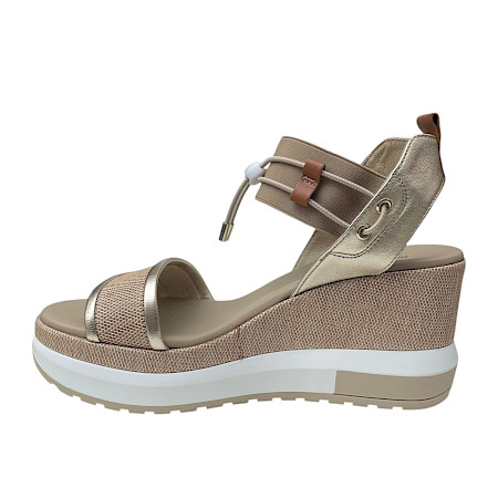 Beige Plateau-Sandalette mit cognacfarbenen und goldenen Details, elastischen Riemen und heller, erhöhter Sohle in einem eleganten, sommerlichen Design. Beige Plateau-Sandalette mit cognacfarbenen und goldenen Details, elastischen Riemen und heller, erhöhter Sohle in einem eleganten, sommerlichen Design.