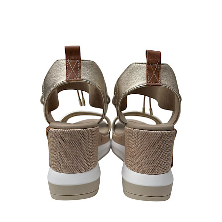 Beige Plateau-Sandalette mit cognacfarbenen und goldenen Details, elastischen Riemen und heller, erhöhter Sohle in einem eleganten, sommerlichen Design. Beige Plateau-Sandalette mit cognacfarbenen und goldenen Details, elastischen Riemen und heller, erhöhter Sohle in einem eleganten, sommerlichen Design.