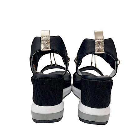 Schwarze Plateau-Sandalette mit breiten Riemen, elastischen Details und heller, erhöhter Sohle in modernem, sportlich-elegantem Design. Schwarze Plateau-Sandalette mit breiten Riemen, elastischen Details und heller, erhöhter Sohle in modernem, sportlich-elegantem Design.