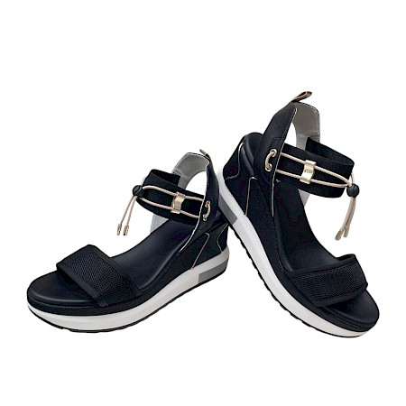 Schwarze Plateau-Sandalette mit breiten Riemen, elastischen Details und heller, erhöhter Sohle in modernem, sportlich-elegantem Design. Schwarze Plateau-Sandalette mit breiten Riemen, elastischen Details und heller, erhöhter Sohle in modernem, sportlich-elegantem Design.